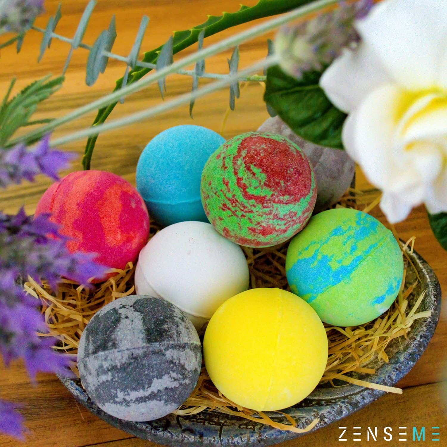 Colorful bath bombs in a nest with flowers on a wooden surface